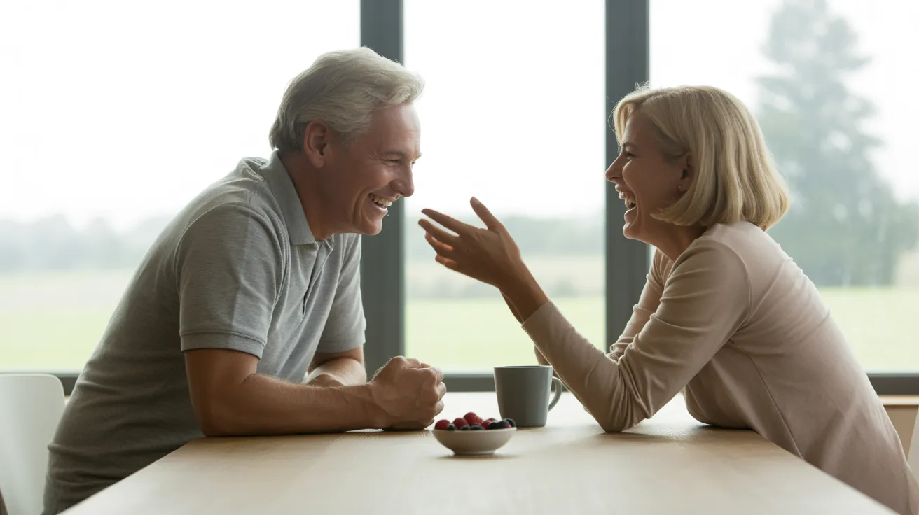 A senior couple shares a joyful laugh over coffee and berries at their kitchen table, bathed in soft, natural light from a window.